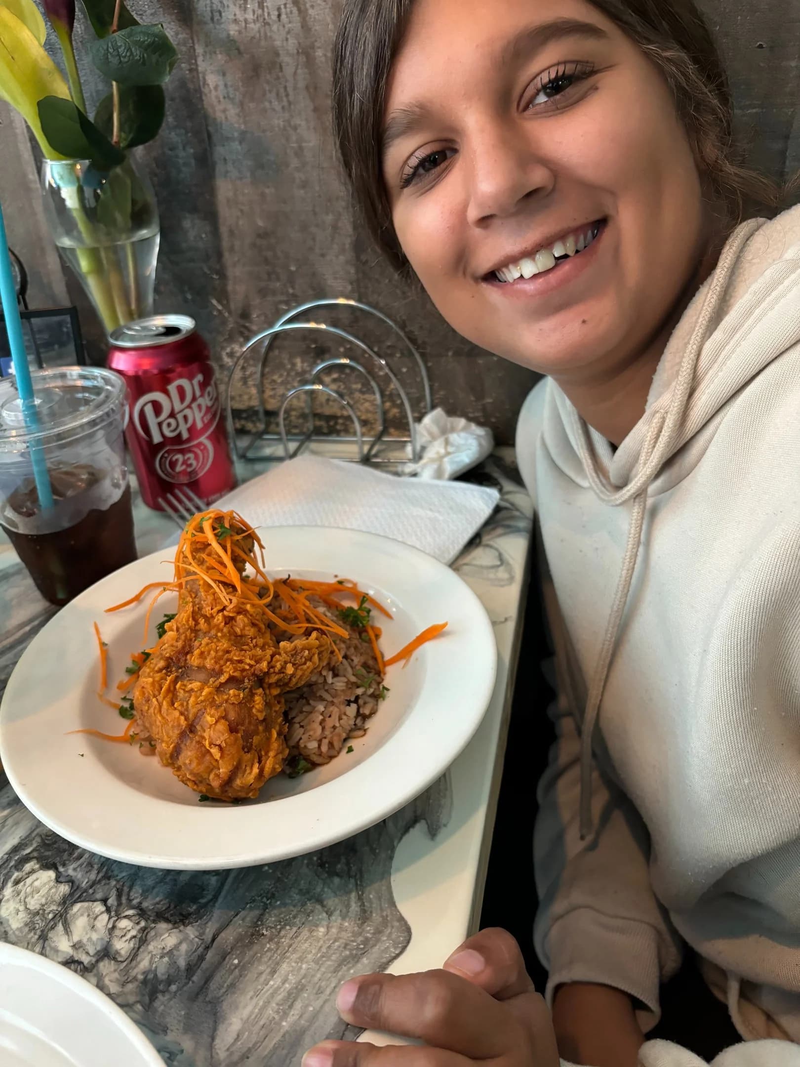 A young woman smiling as she enjoys a meal out